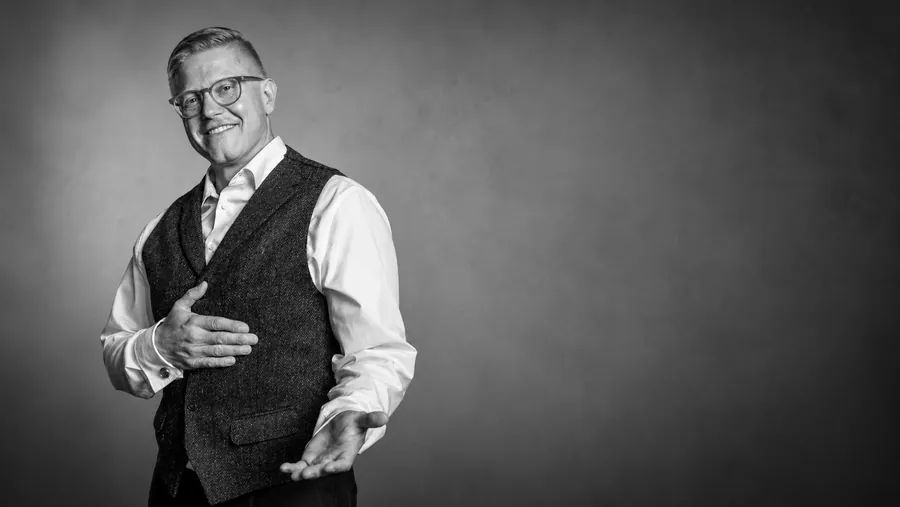 Dennis Holewa im Porträt mit einladender Handgeste